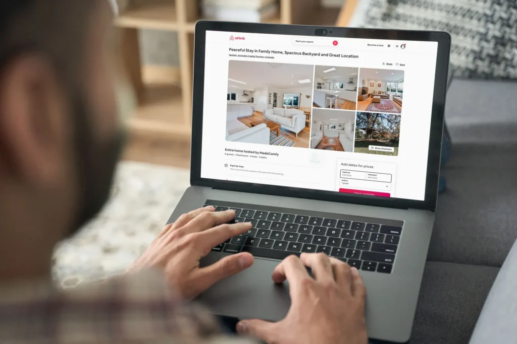 Person browsing Airbnb listings on laptop.