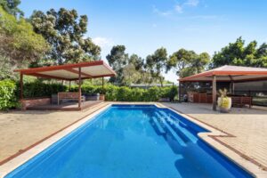 A beautiful swimming pool and two gazebos in the backyard at the property Hearth & Home that is suitable for a large family Airbnb near Perth