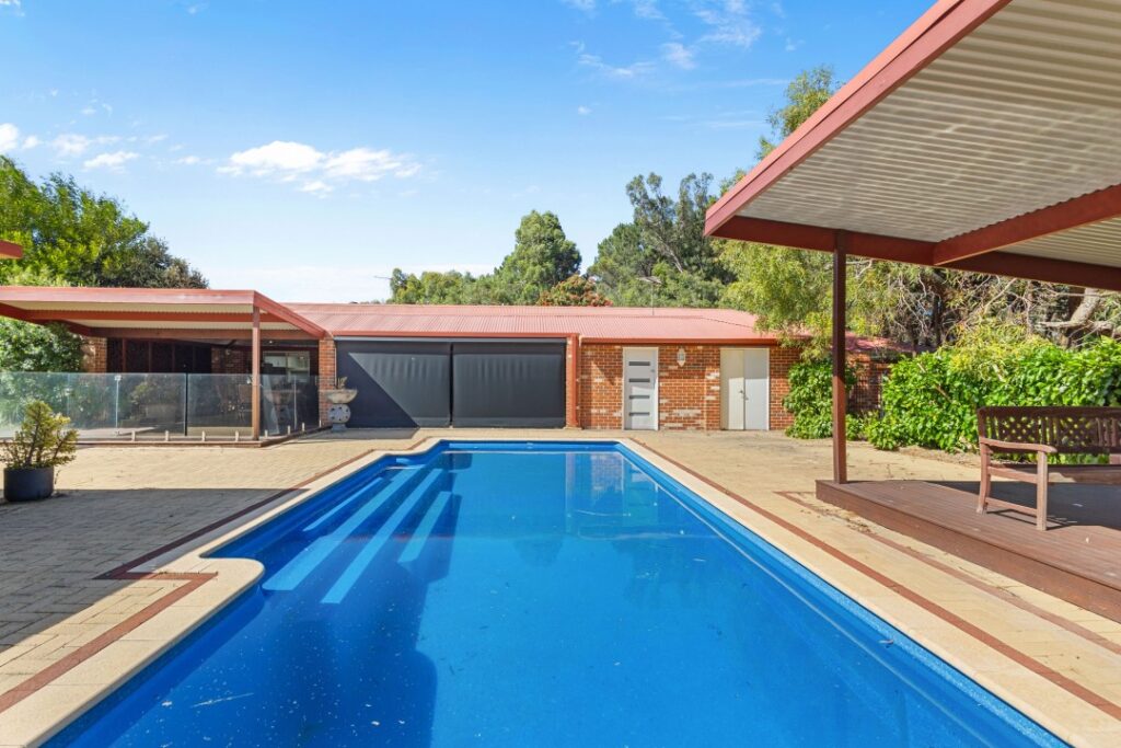 A beautiful swimming pool area in the backyard at the property Hearth & Home.