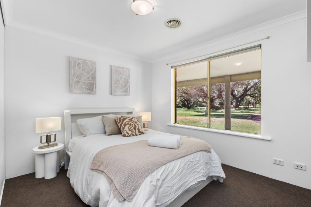 The second bedroom with a queen bed, along with two bedside tables and two bedside lamps.