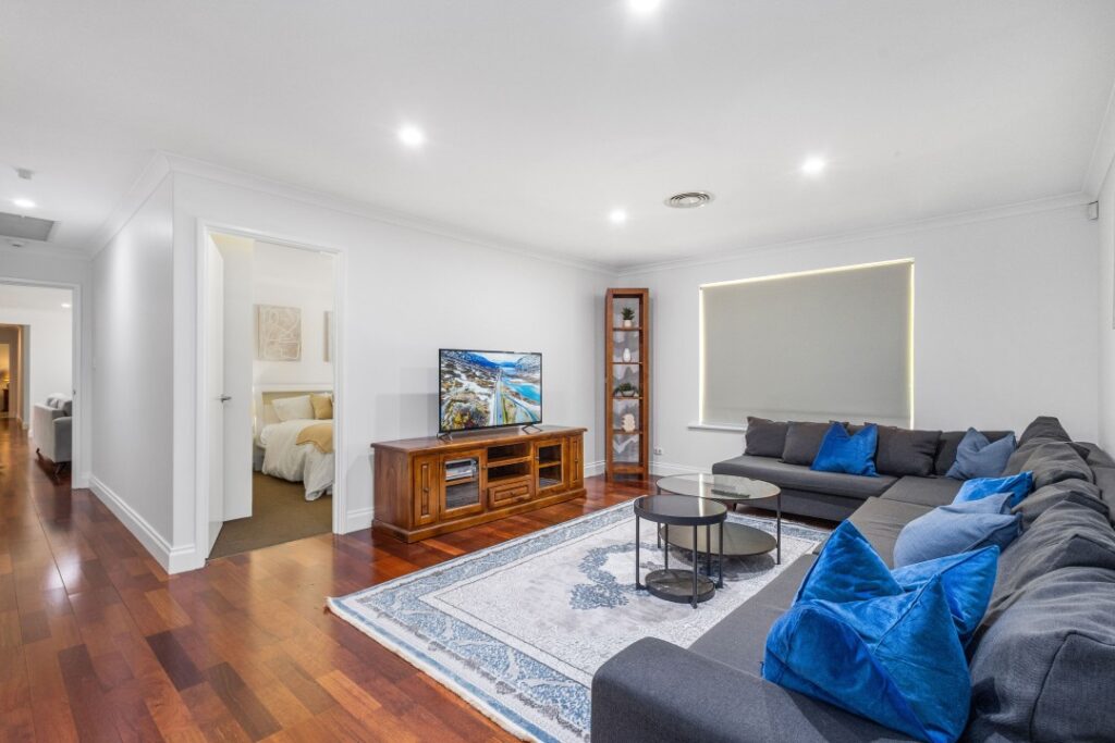 Second living room with long sofa and TV.