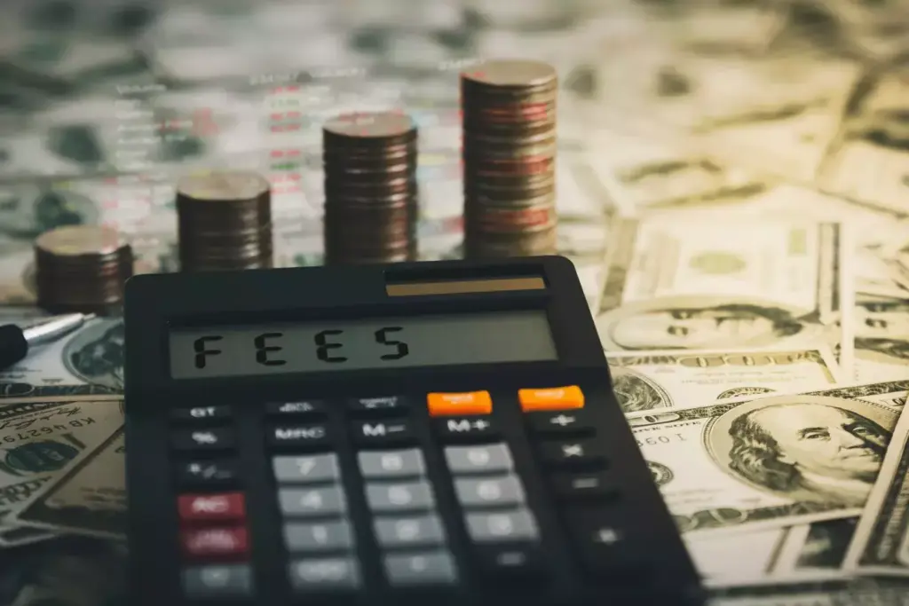 Calculator, coins, and dollar bills. About hosting fees.