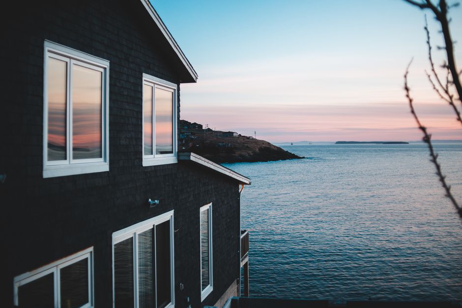 Beachfront house with ocean views at sunset, reflecting leisure property characteristics.