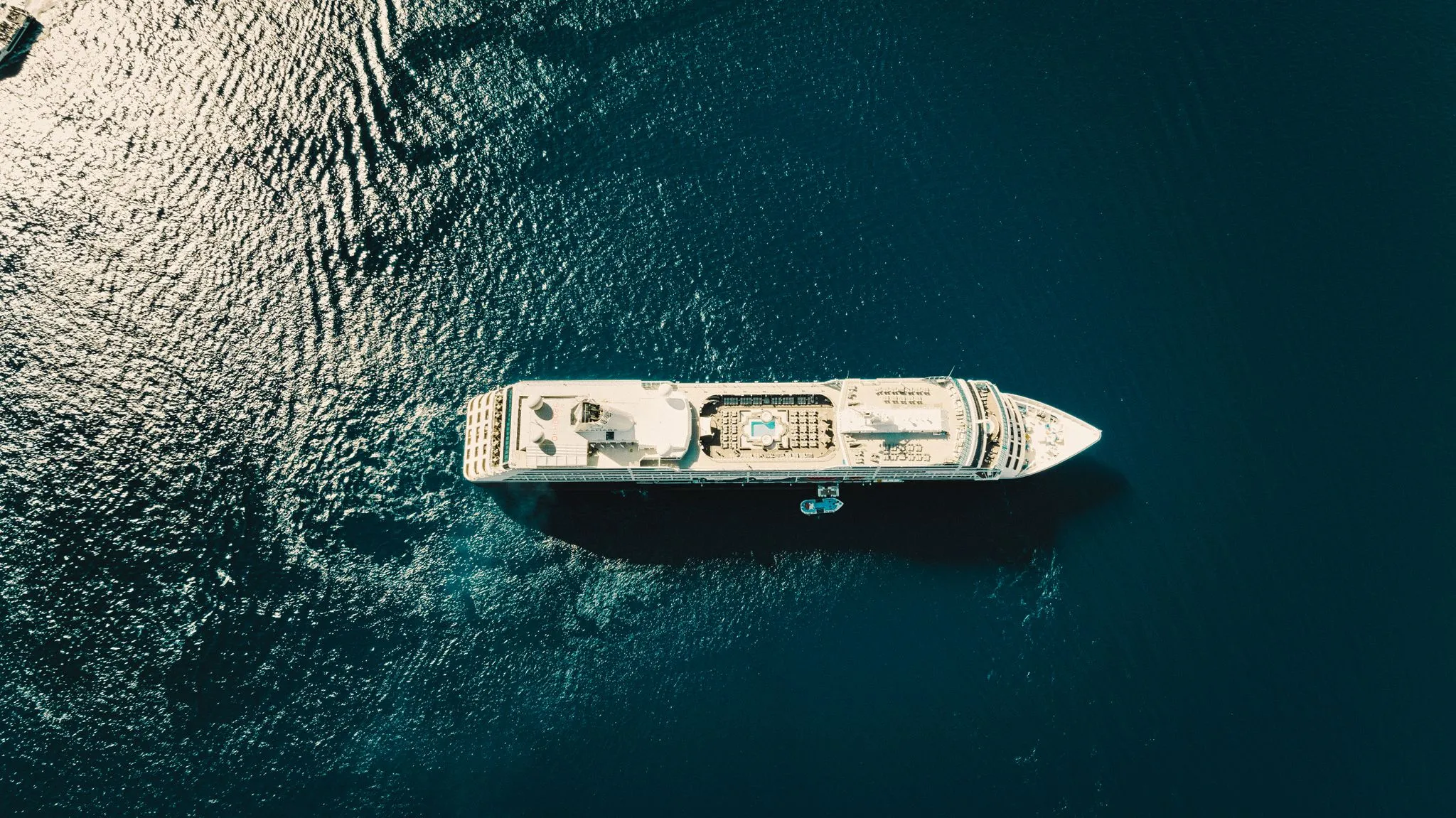 Top-down aerial view of a cruise ship on open blue water