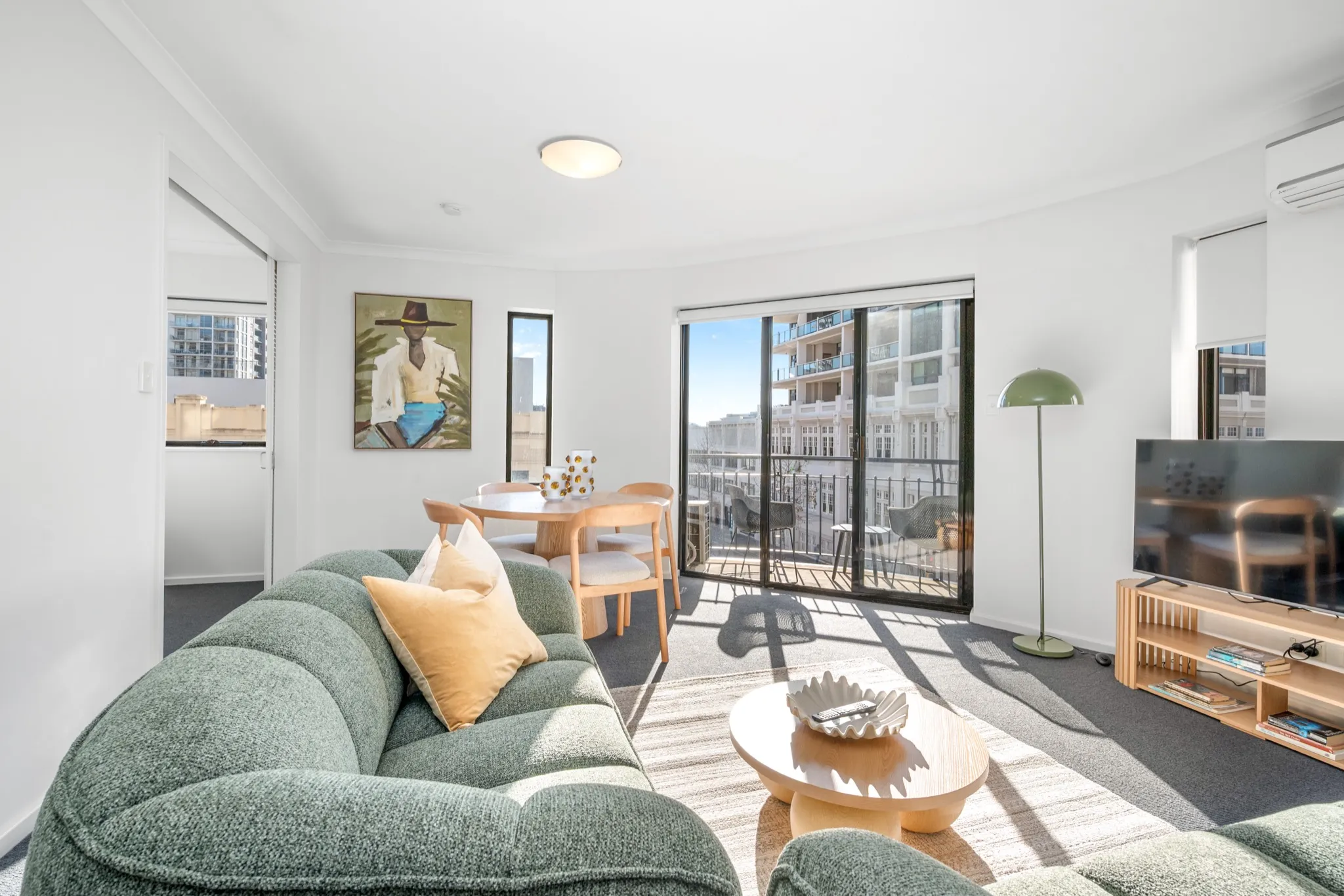 Living room of a Perth CBD apartment with balcony and city view