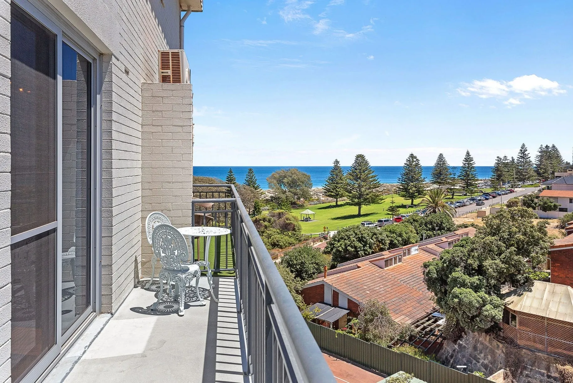 Balcony of a Scarborough apartment managed by Sepal Stays, looking over Norfolk pines to the Indian Ocean