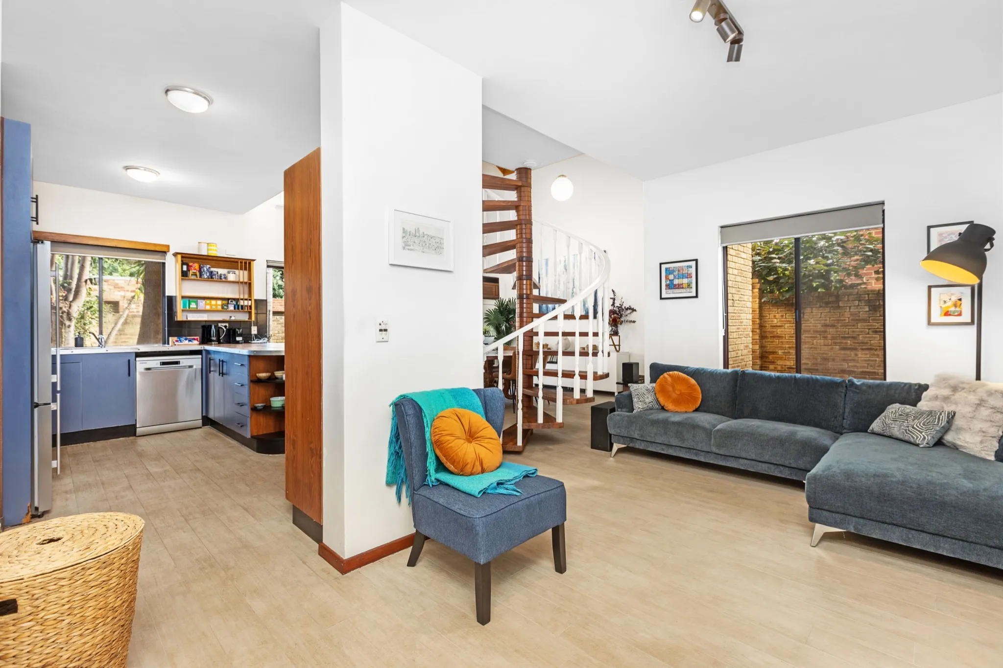 Living room of a Subiaco short-term rental home with spiral staircase and open kitchen
